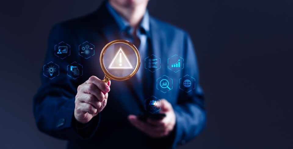 Businessman,Uses,A,Magnifying,Glass,To,Scrutinize,A,Risk,Alert